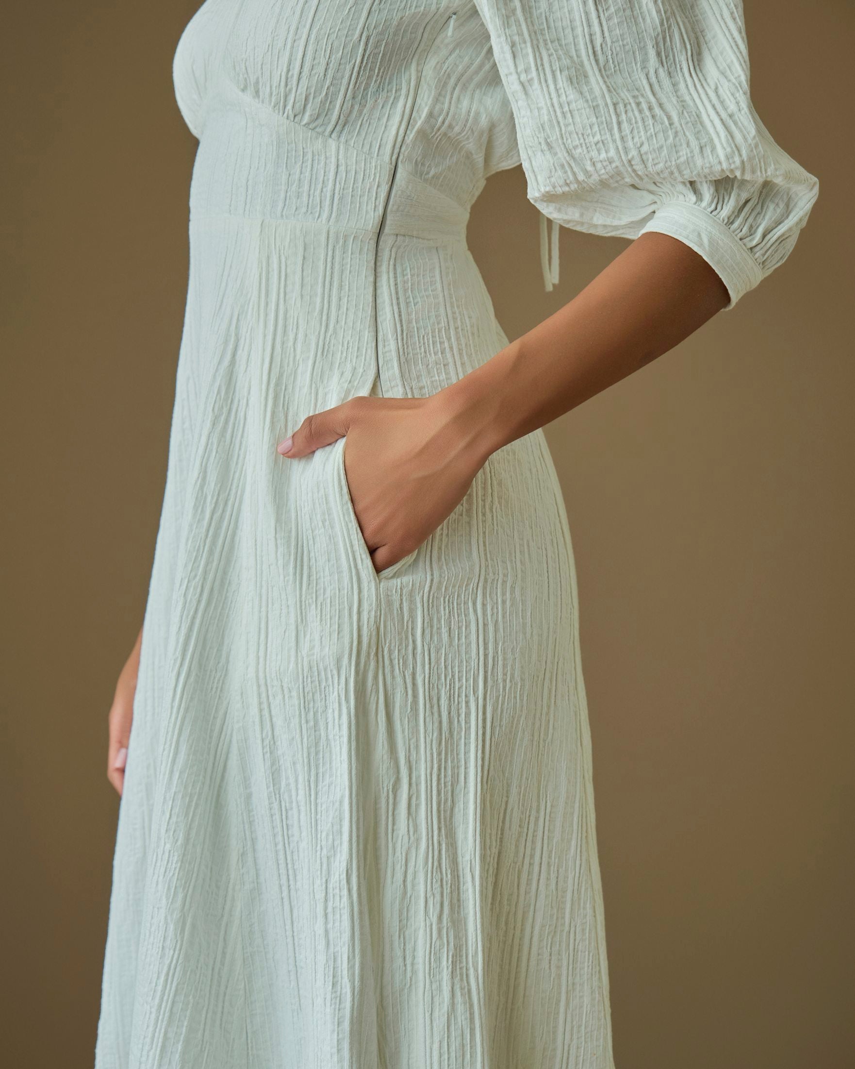 Model showcasing a Nalla cotton dress featuring a stylish open back and pockets, made from high-quality cotton.