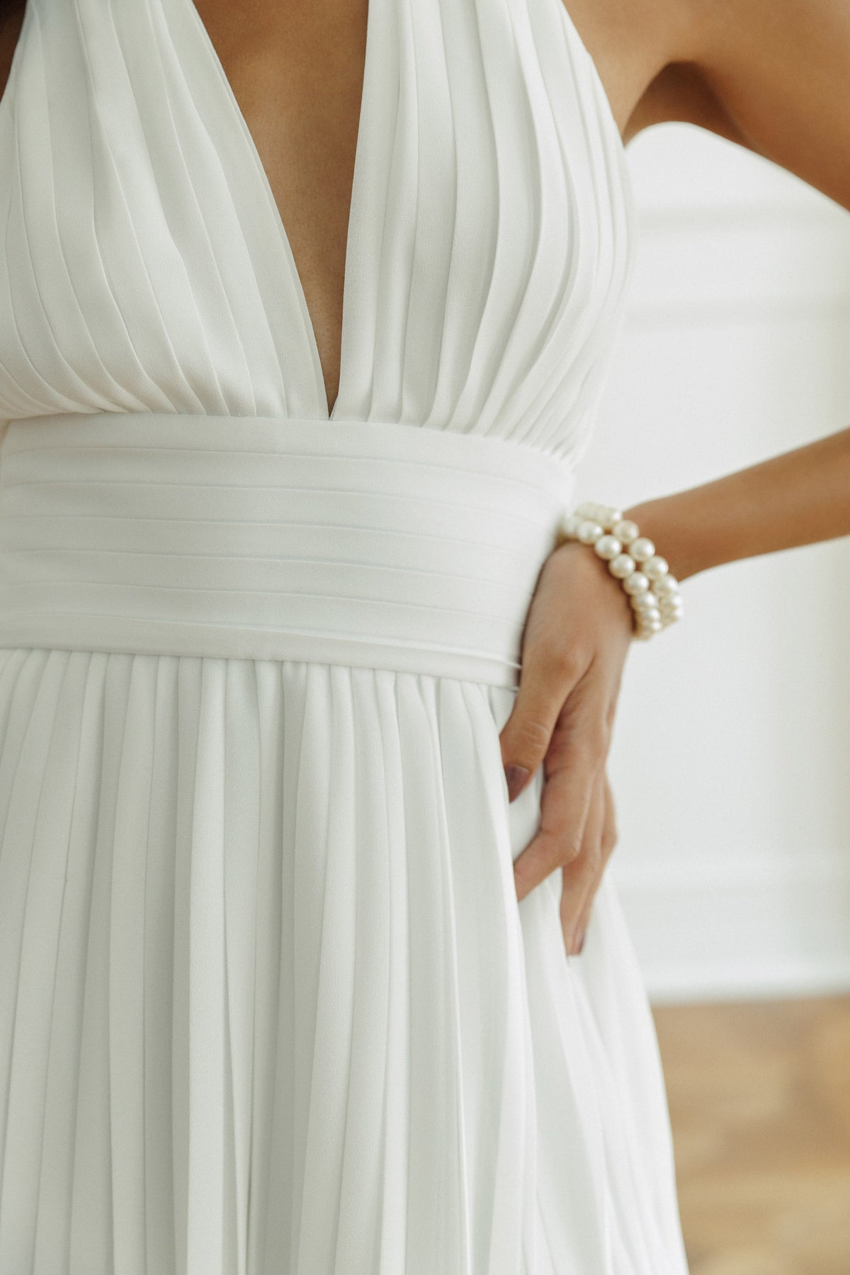Adrian white mini dress featuring fine pleated fabric and fitted waist