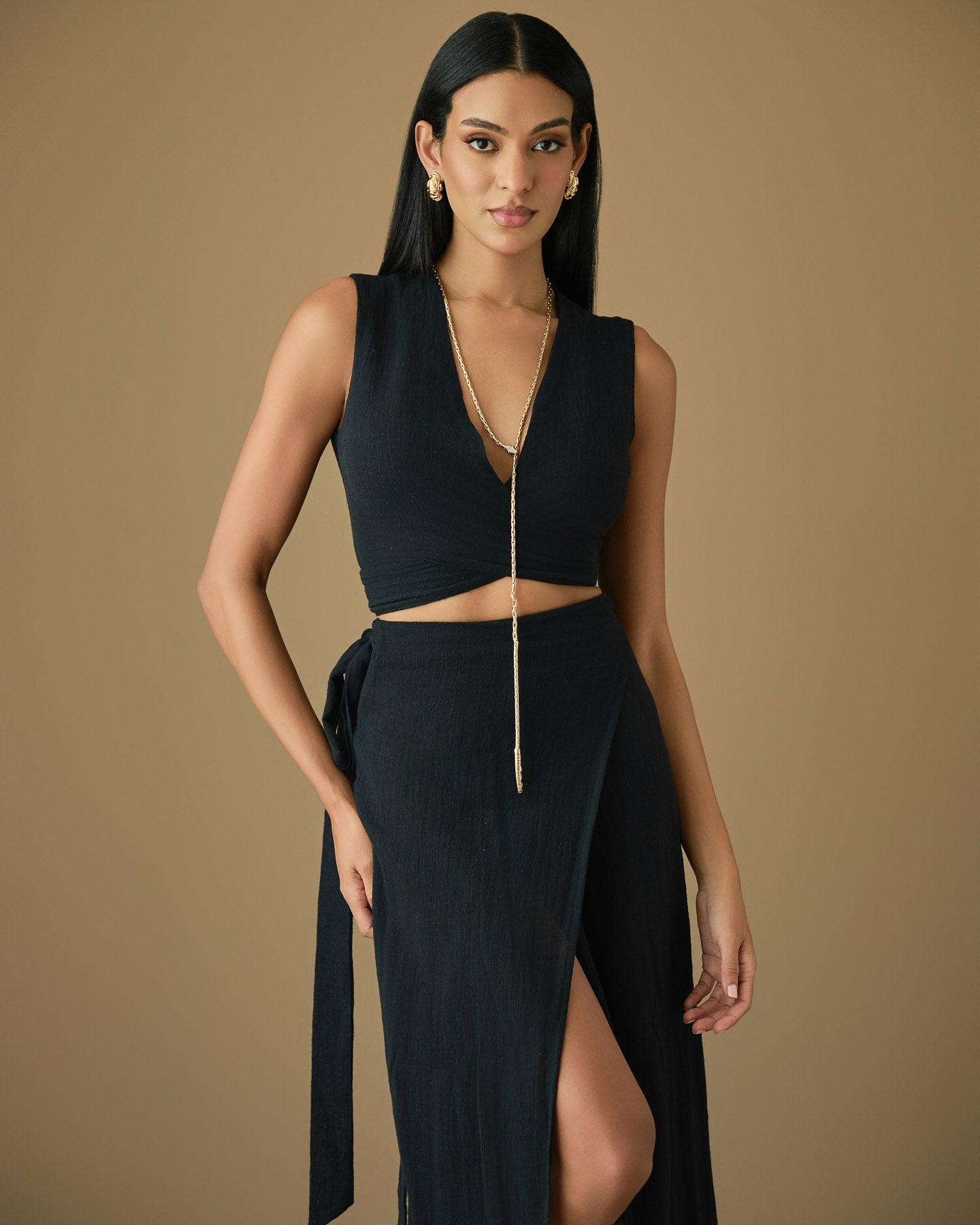 Black cotton two-piece set featuring a wrap top and midi skirt with a subtle front slit