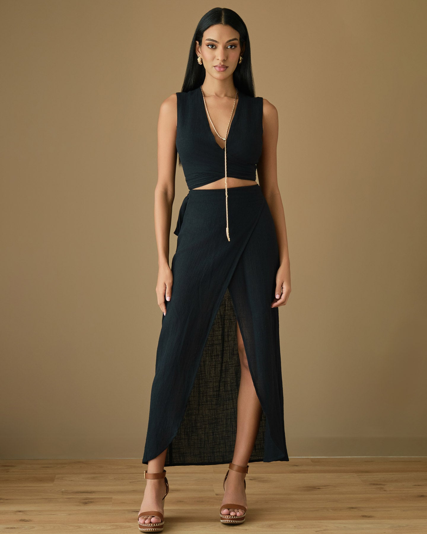 Sleeveless black cotton wrap top paired with a matching wrap skirt, modern and effortless