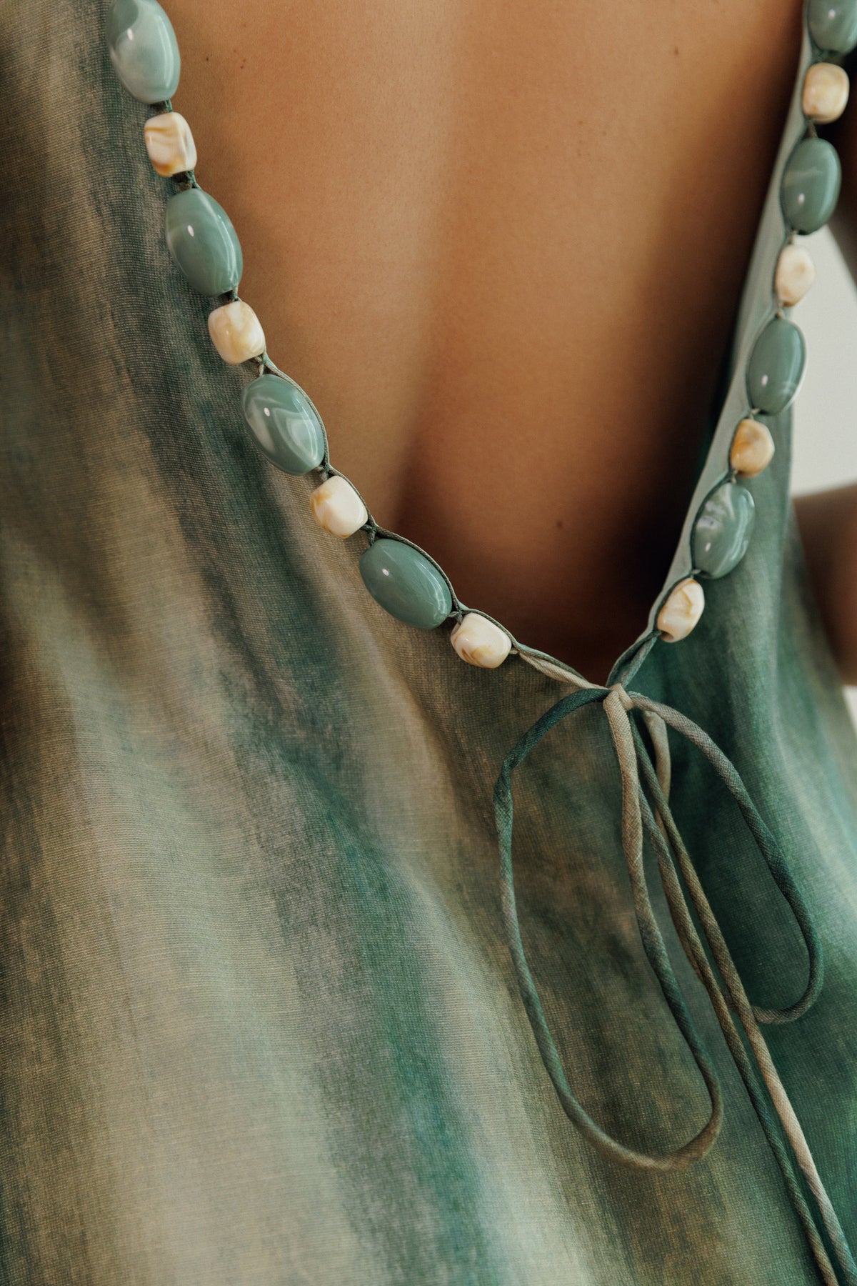 Back view of the Evi maxi dress showing decorative beaded detailing and tie-back straps.