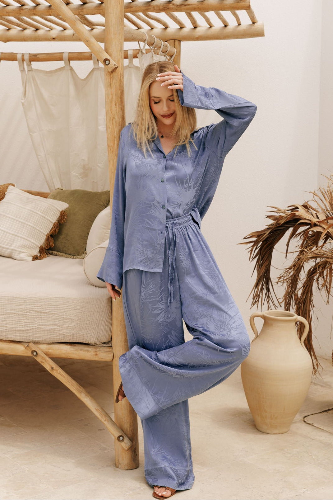 Elegant dusty blue satin matching set with oversized shirt and flowy pants, designed for luxury resortwear and effortless vacation styling.