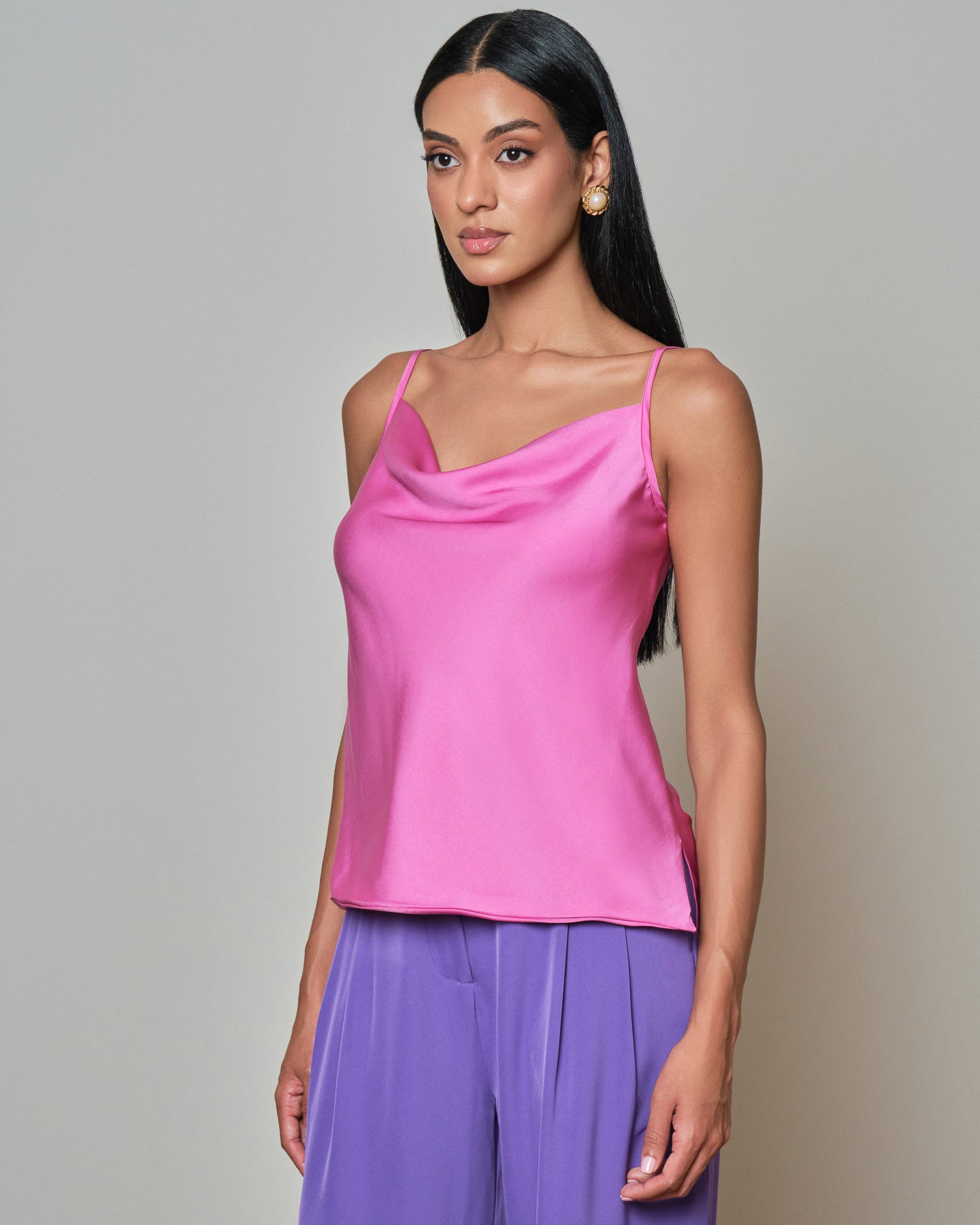 Pink satin camisole top with a soft draped neckline and delicate spaghetti straps