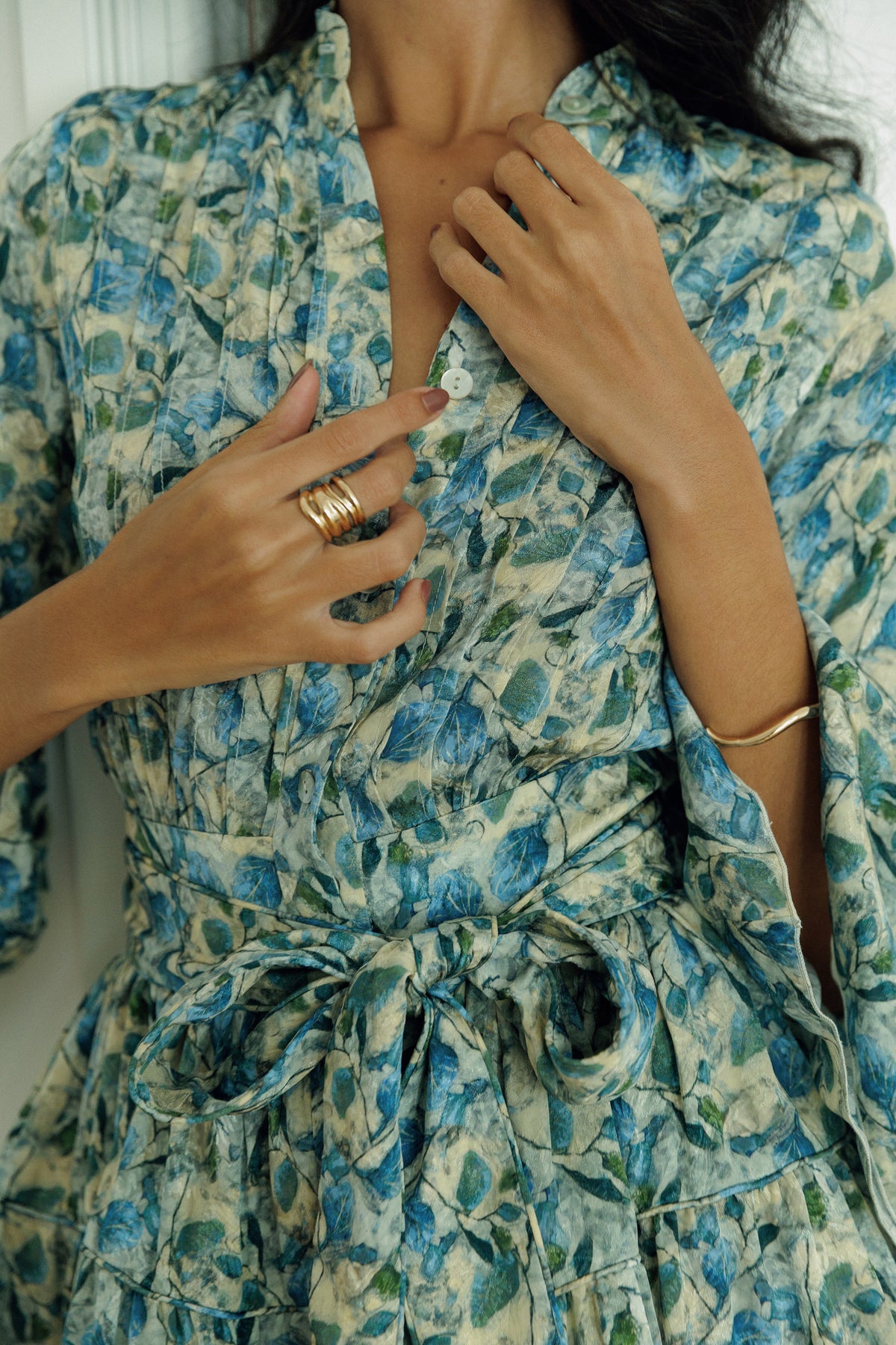Model wearing the Thalia green and blue floral mini dress with tie belt.