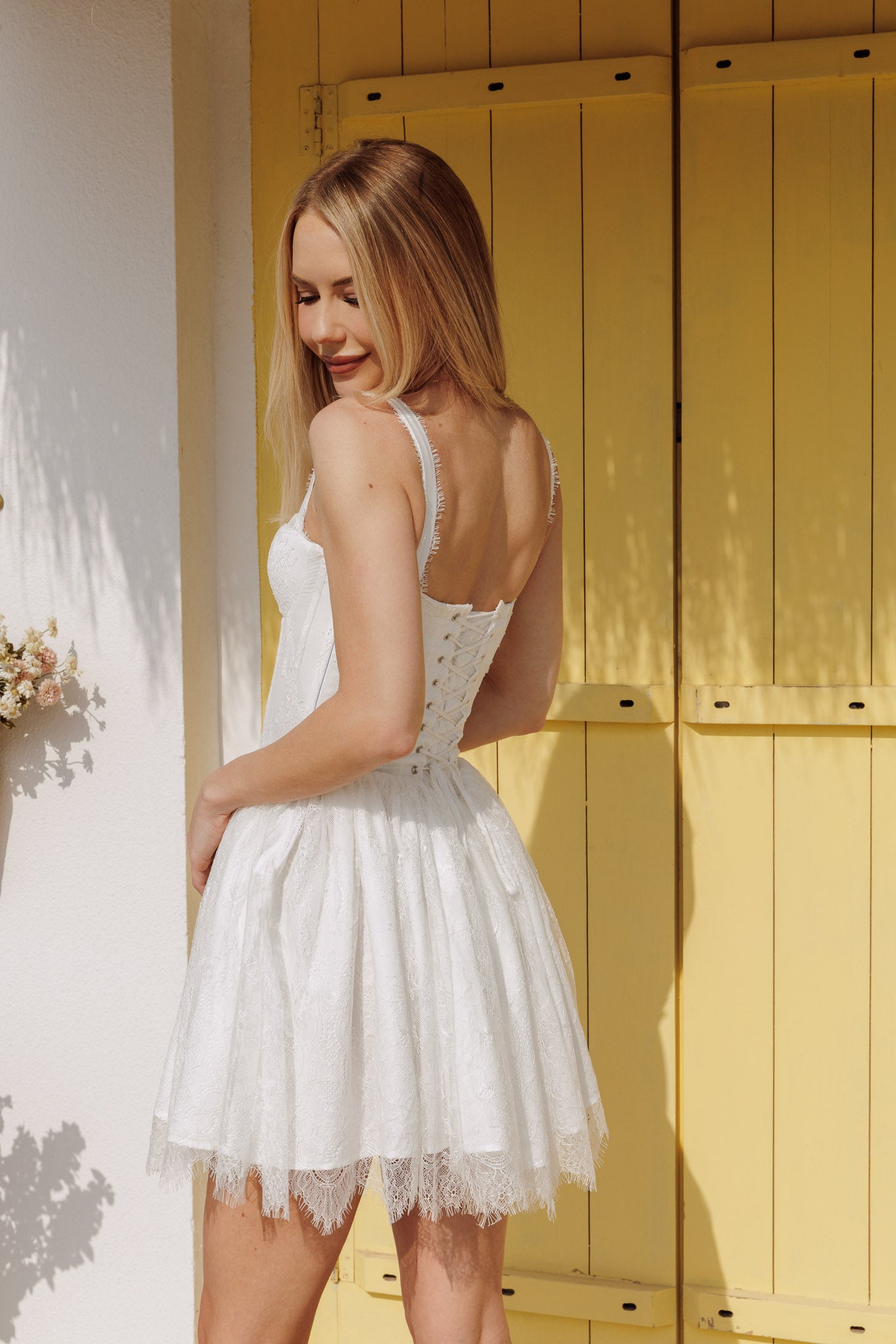 White corset style lace mini dress with structured bodice and flared hem, feminine summer look
