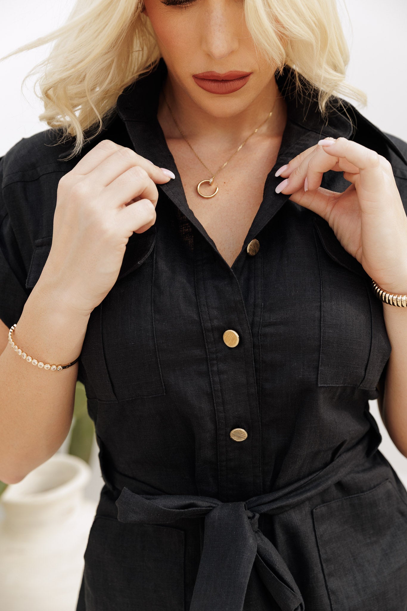 Black linen utility playsuit with button front and tailored fit, versatile day-to-evening piece