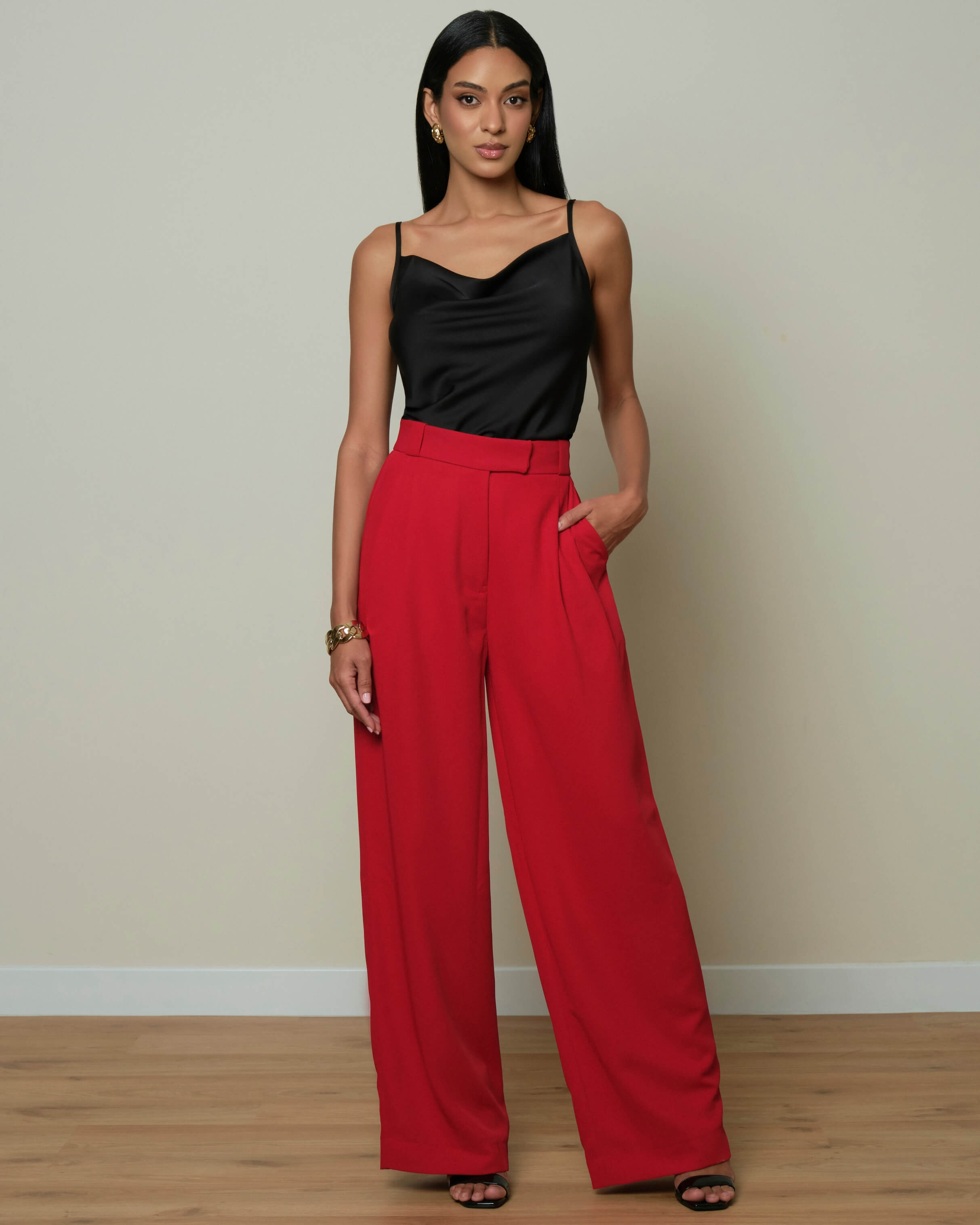 Black satin camisole top with a soft draped neckline and delicate spaghetti straps