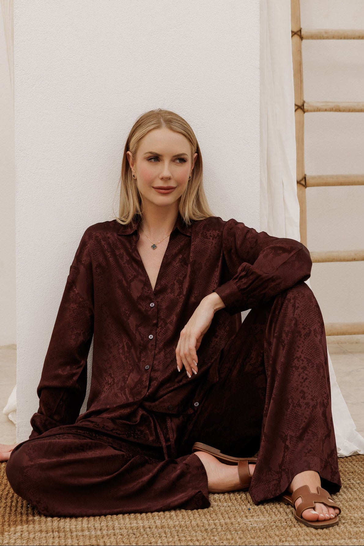 Elevated satin co-ord in deep wine burgundy with subtle pattern, featuring a loose-fit shirt and relaxed wide-leg pants for chic vacation wear.