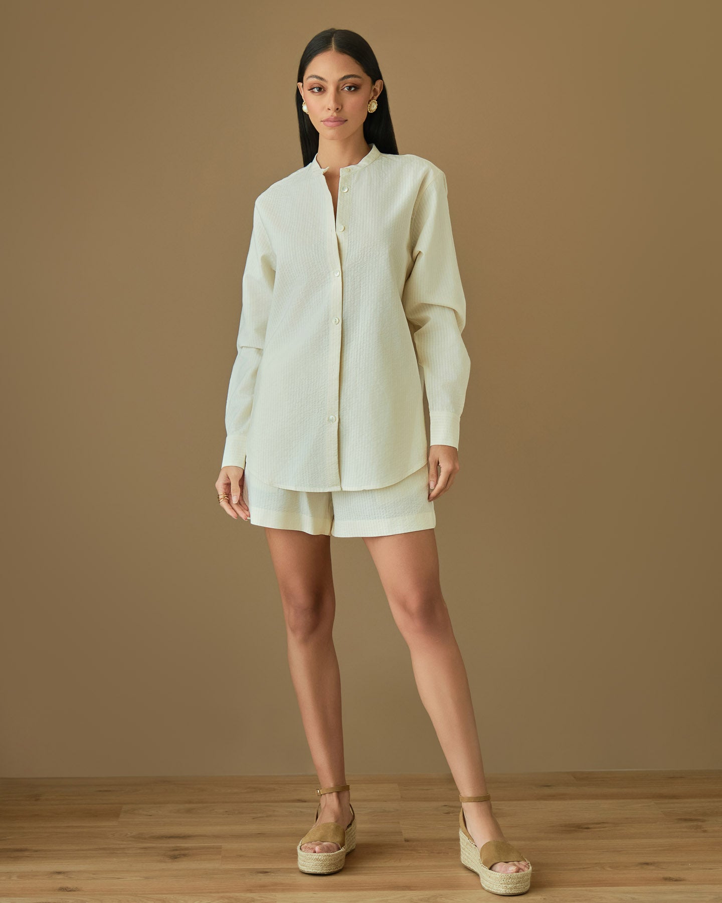 Cream cotton two piece set featuring button down shirt and loose fit shorts