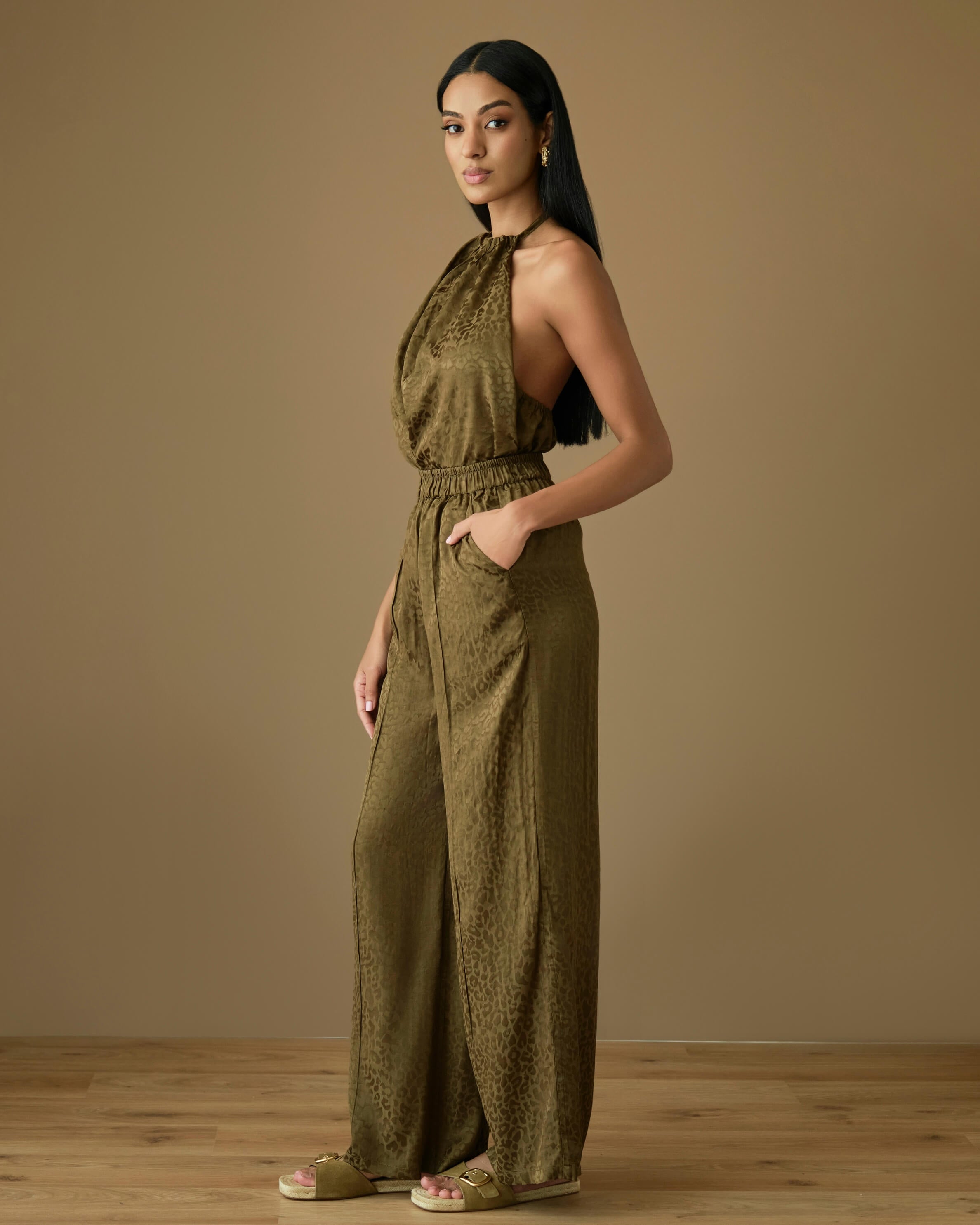 Olive viscose two-piece set featuring a halter neck draped top with soft gathers at the neckline, paired with high-waisted wide-leg trousers with an elasticated waistband. Lightweight, fluid viscose fabric with a silky feel and elegant drape, perfect for effortless resort and evening styling.